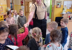 Pan Rafał pokazuje dzieciom strój strażaka