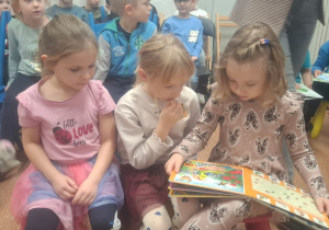 Trzy dziewczynki oglądają książkę