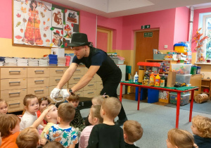 Iluzjonista podaje dziecku złączone obręcze