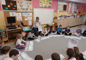 Pani Agnieszka objaśnia dzieciom zadania w książeczce