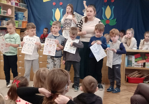 Kikoro dzieci trzyma kartki ze wzorami haftów kaszubskich