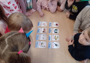 Kikoro dzieci przy stoliku dopasowuje napisy kaszubskie do obrazków