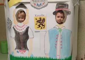 Dziewczynka i chłopiec w fotobudce ze strojami kaszubskimi