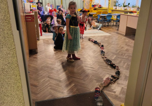 Dzieci patrzą na ustawione do drzwi buty