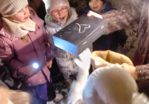 Dzieci patrzą na odnaleziona skrzynkę w ogrodzie