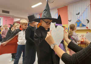 Chłopiec wbija szpilkę w papierowe serce