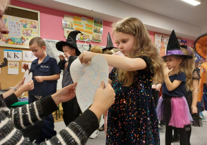 Dzieci podczas wróżby z imionami na papierowych sercach