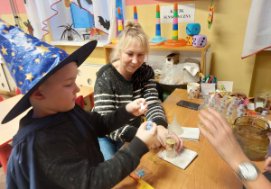 hłopiec z panią Moniką przygotowuje magiczną butelkę