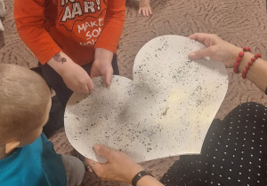 Chłopiec wbija szpilkę w papierowe serce