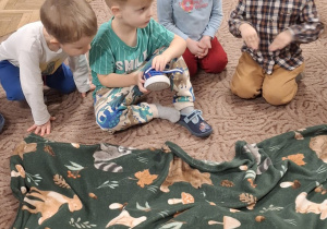 Dzieci siedzą przed matą ze zwierzątkami