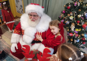 Dziewczynka przytula się do Mikołaja