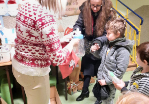 Dwóch chłopców z mamą podczas losowania