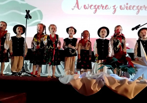 Dzieci na scenie śpiewają pastorałkę