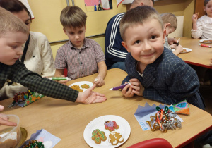 Trzech chłopców ozdabia pierniczki