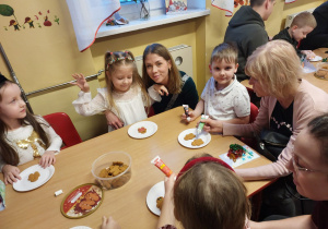 Dzieci z rodzicami ozdabiają pierniczki