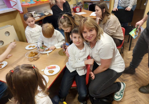 Dzieci z rodzicami ozdabiają pierniczki