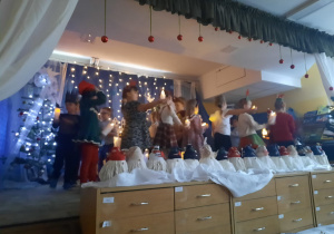 Dzieci z lampionami idą na scenie