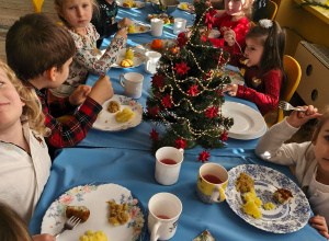 Dzieci z paniami podczas obiadu wigilijnego