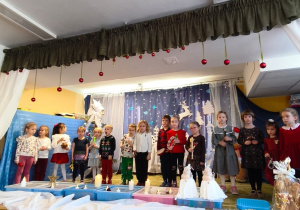 Dzieci z grupy Biedronki z instrumentami stoją na scenie