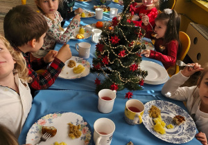 Dzieci z paniami podczas obiadu wigilijnego