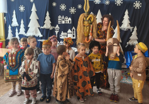 dzieci stoją w strojach afrykańskich, a pani Asia trzyma maskę