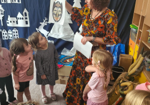 Pani Asia pokazuje dzieciom afrykańskie maski