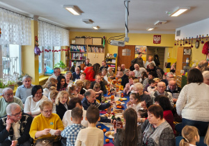 Babcie i dziadkowie z wnukami przy poczęstunku