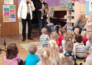 Pan Witek mówi do dzieci, a pan Jacek trzyma trąbkę i flugelhorn