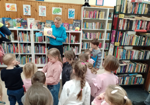 Pani bibliotekarka pokazuje dzieciom książkę