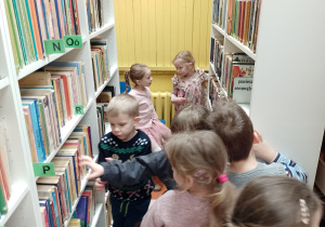 Dzieci oglądają książki na regałach