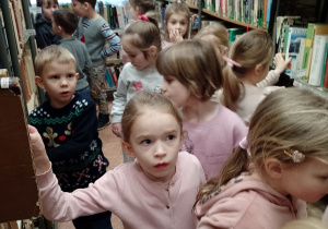 Dzieci oglądaja ksiązki na regałach