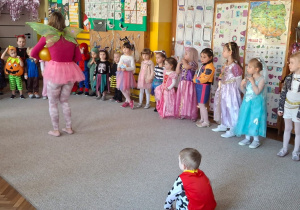 Dzieci stoją w kole a w środku wodzirejka