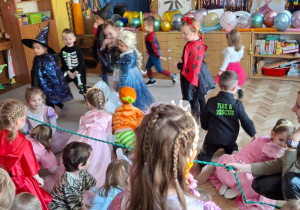 Dzieci przechodzą pod liną