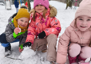 Troje dzieci z ulepionym bałwankiem