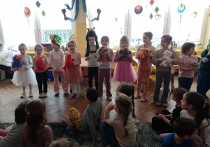 Kikoro dzieci stoi obok siebie i trzyma w rękach maskotki zwierząt