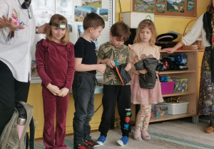 Czworo dzieci trzyma przedmioty do plecaka