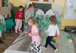 Kilkoro dzieci pokonuje trasę na nartach, po linie po krążkach