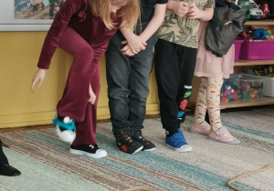 Dziewczynka zakłada na stopę raki