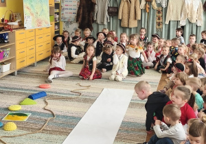 Dzieci siedzą na dywanie