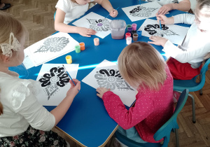 Kilkoro dzieci maluje wzór parzenicy
