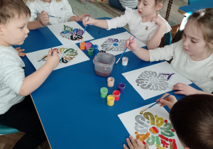Kilkoro dzieci maluje wzór parzenicy
