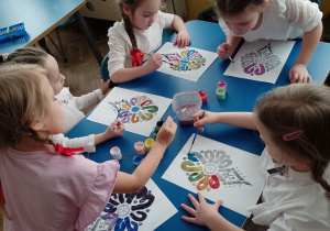 Kilkoro dzieci maluje wzór parzenicy