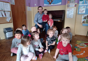 Pan Piotr z dziećmi z grupy I na tle pianina