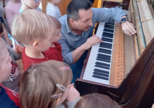 Pan Piotr pokazuje dzieciom budowę pianina