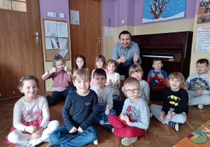 Pan Piotr z dziećmi z grupy V na tle pianina