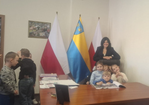 Kilkoro dzieci na fotelu, a z tyłu Pani Prezydent