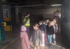 Dzieci stoją w budynku elektrociepłowni