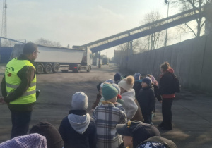 Dzieci stoją i oglądają jadące samochody do elektrociepłowni