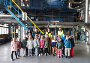 Dzieci z paniami i pracownikami w budynku elektrociepłowni