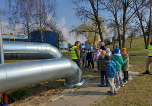 Dzieci oglądają rury, którymi dochodzi ciepło